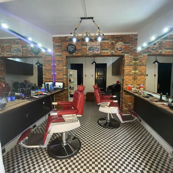 Interior de la barbería: sillones rojos y piso ajedrezado